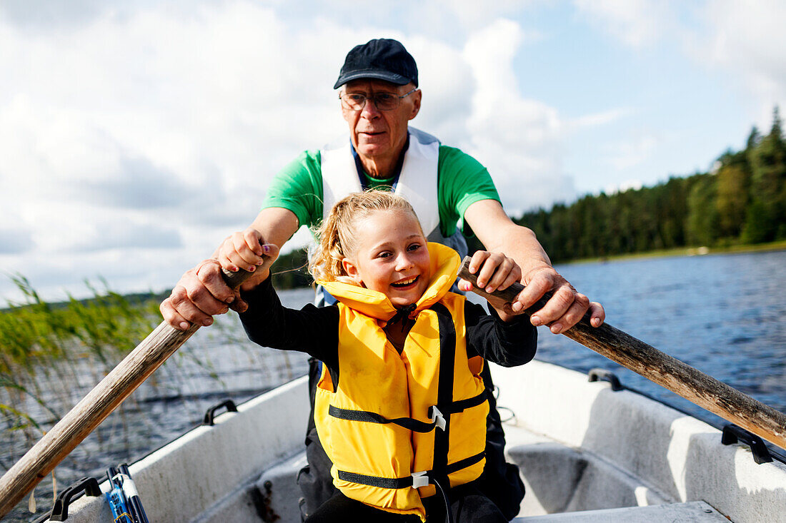 Grandfather and granddaughter rowing
