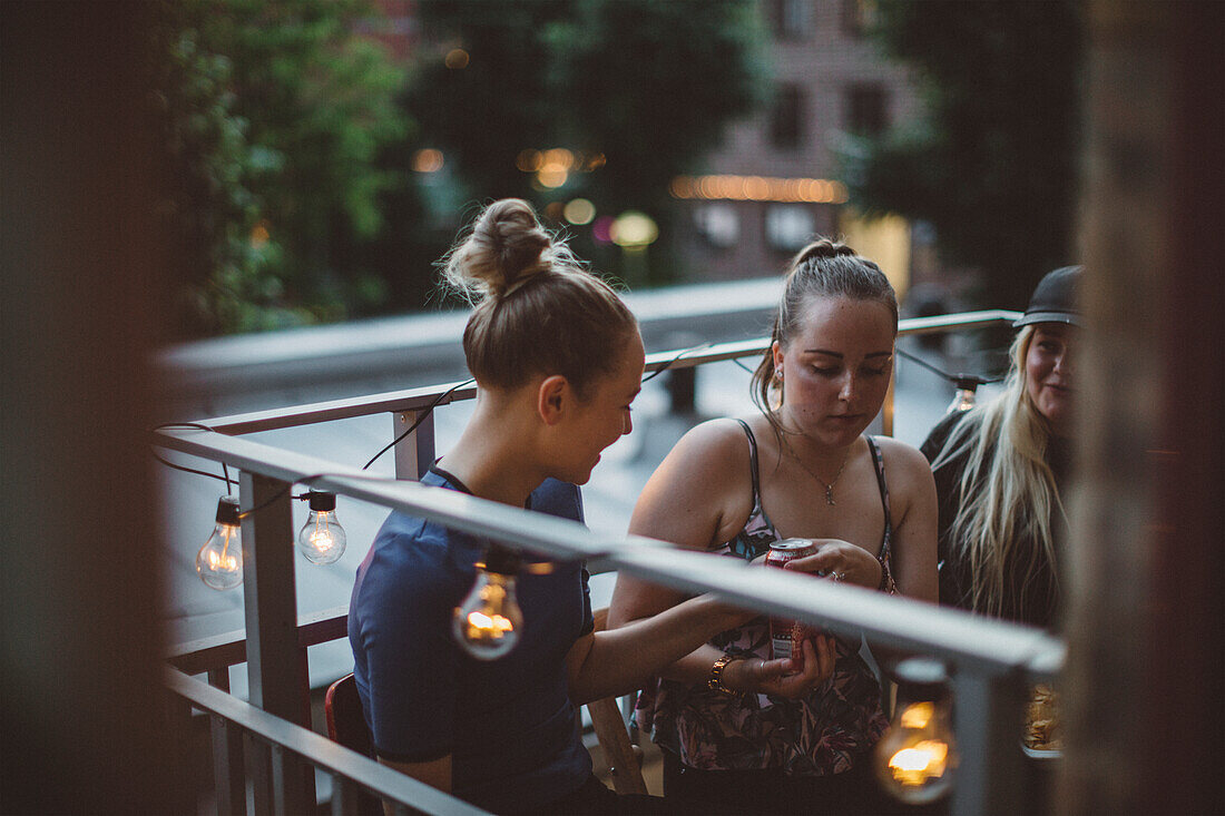 Smiling women talking on balcony