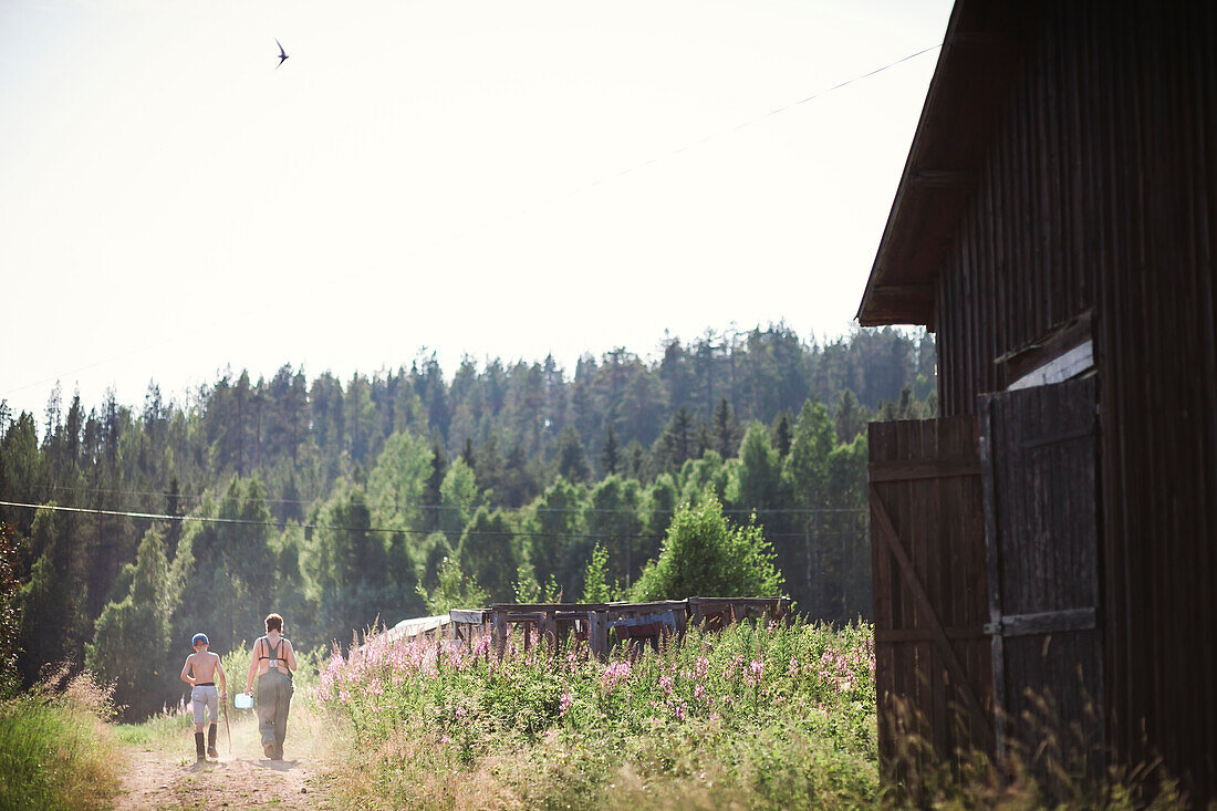 Woman and boy walking down dirt track