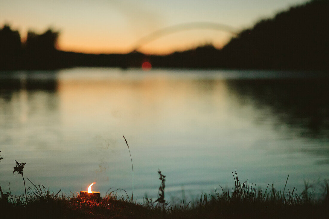 Candle burning by river