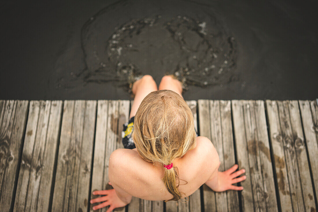 Boy sitting on jetty