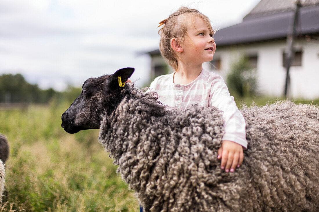 Mädchen umarmt Schaf