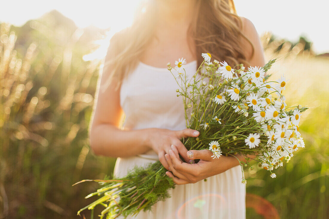 Frau hält weiße Blumen