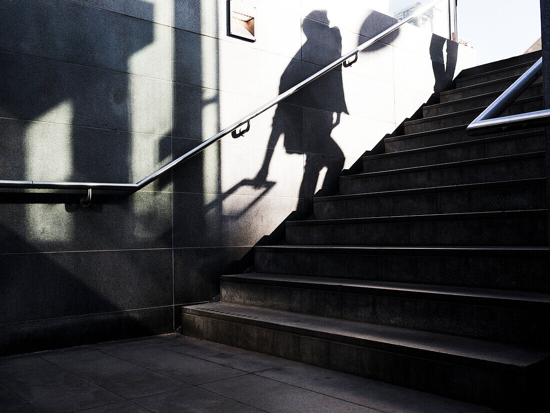 Schatten einer Person, die eine Treppe hinaufgeht