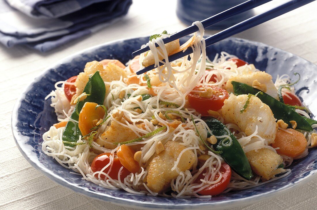 Thai noodles with vegetables and pieces of cod