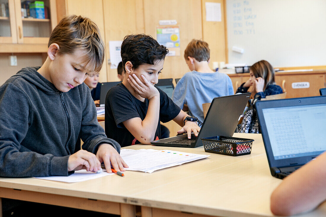 Jungen benutzen Laptops in der Schule