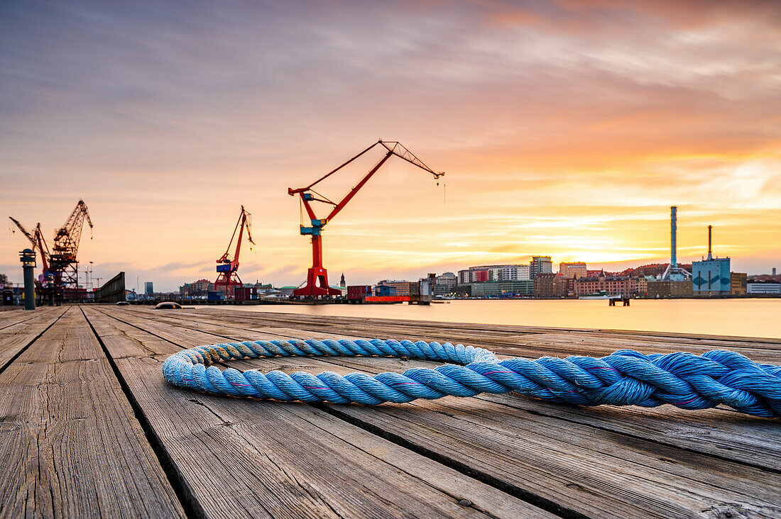 Rope on wooden deck, port on background