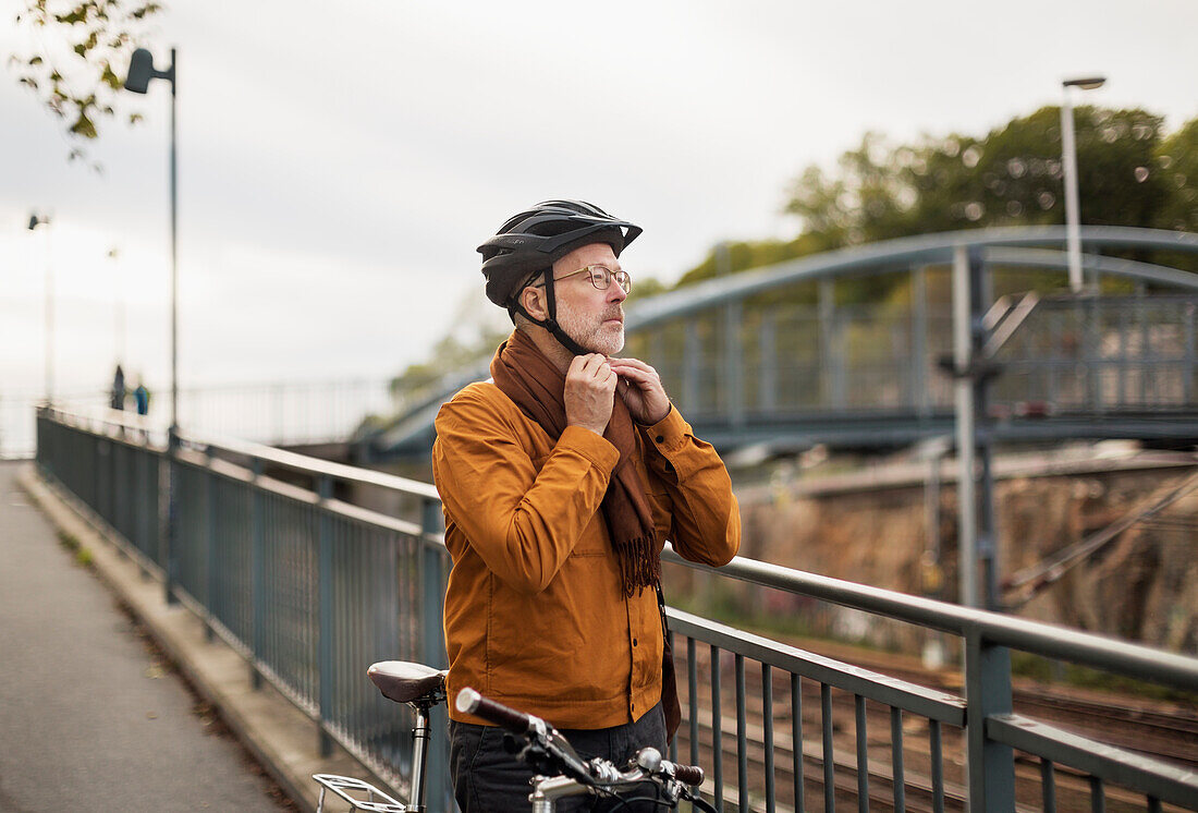 Mann setzt Fahrradhelm auf