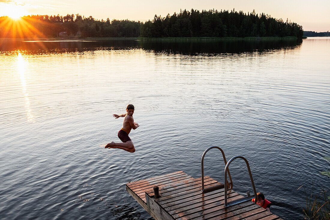 Boy jumping into lake
