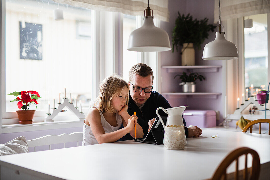 Father with daughter using digital tablet