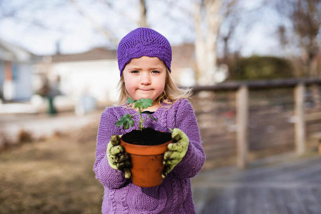 Girl holding pot with plant