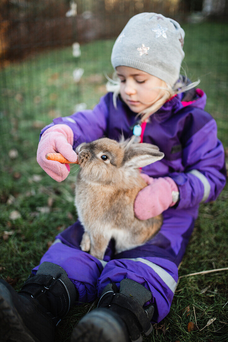 Mädchen füttert Kaninchen