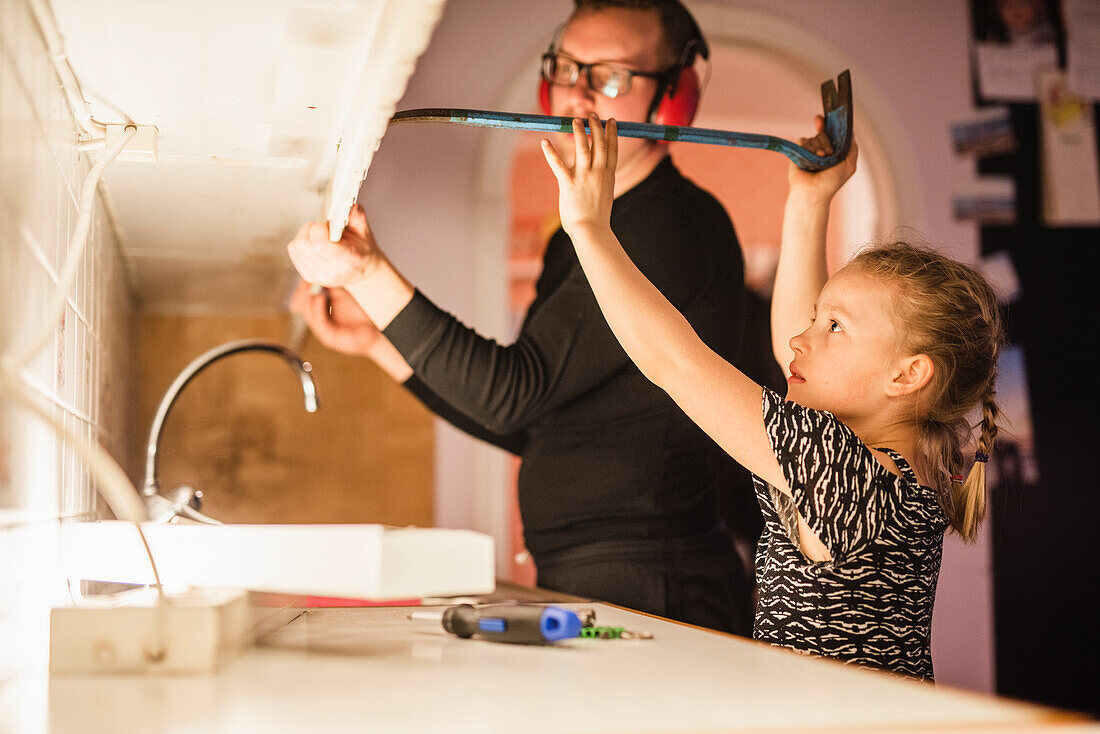 Father and daughter disassembling cupboards