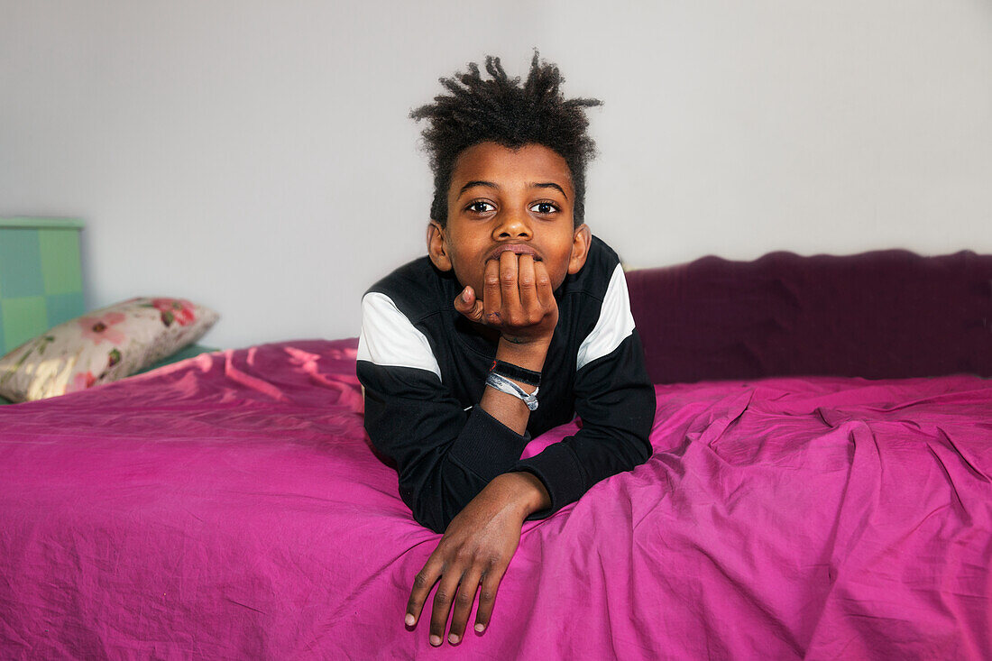 Boy on bed looking at camera