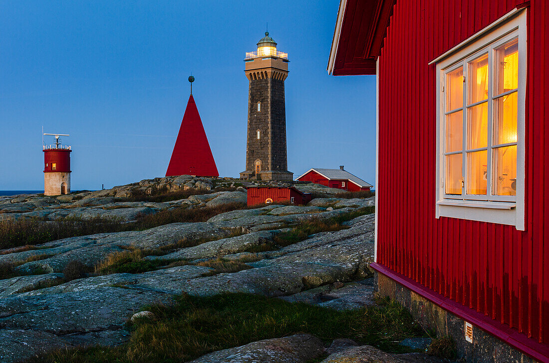 Leuchtturm und Gebäude in der Abenddämmerung