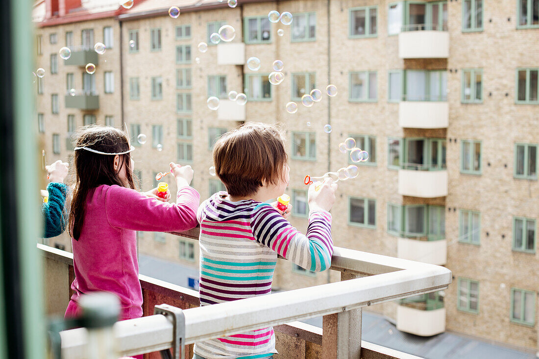 Girls on balcony blowing bubbles