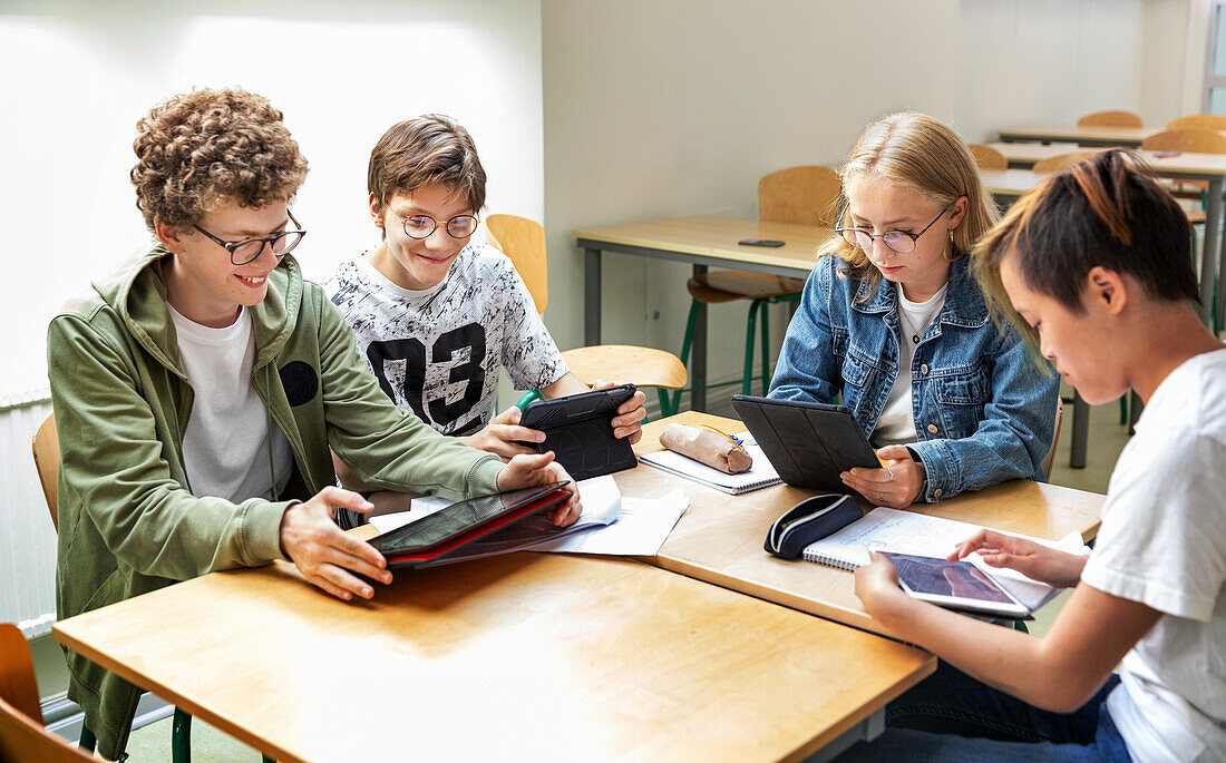 Teenagers in classroom using digital tablets