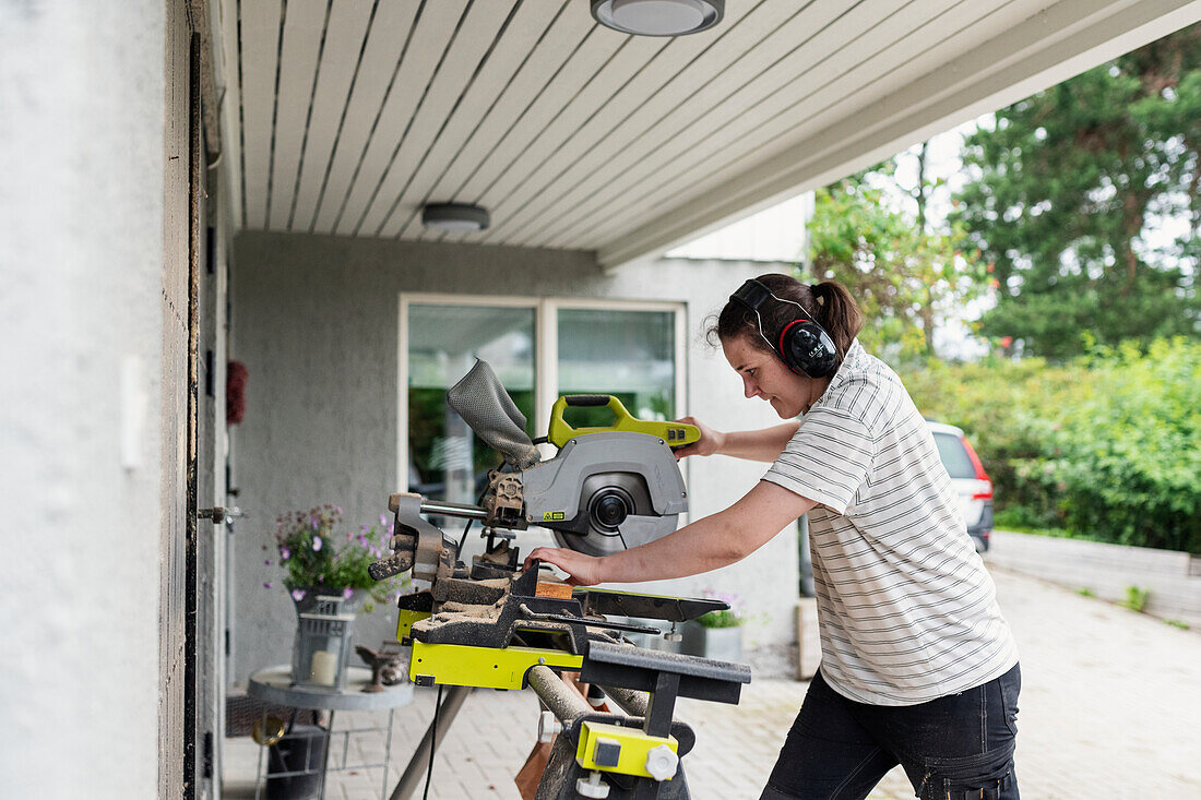 Woman using bench saw