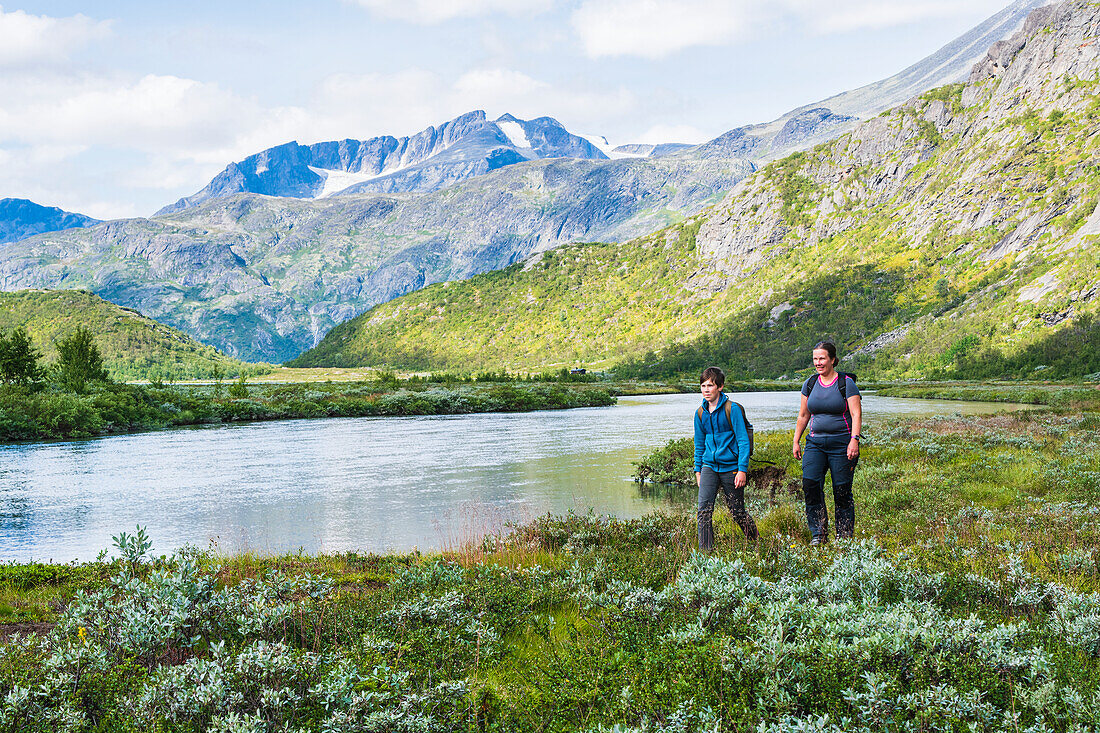 Mother and son hiking near mountains river