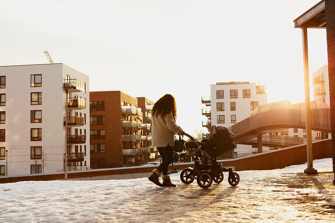 Frau zu Fuß mit Kinderwagen