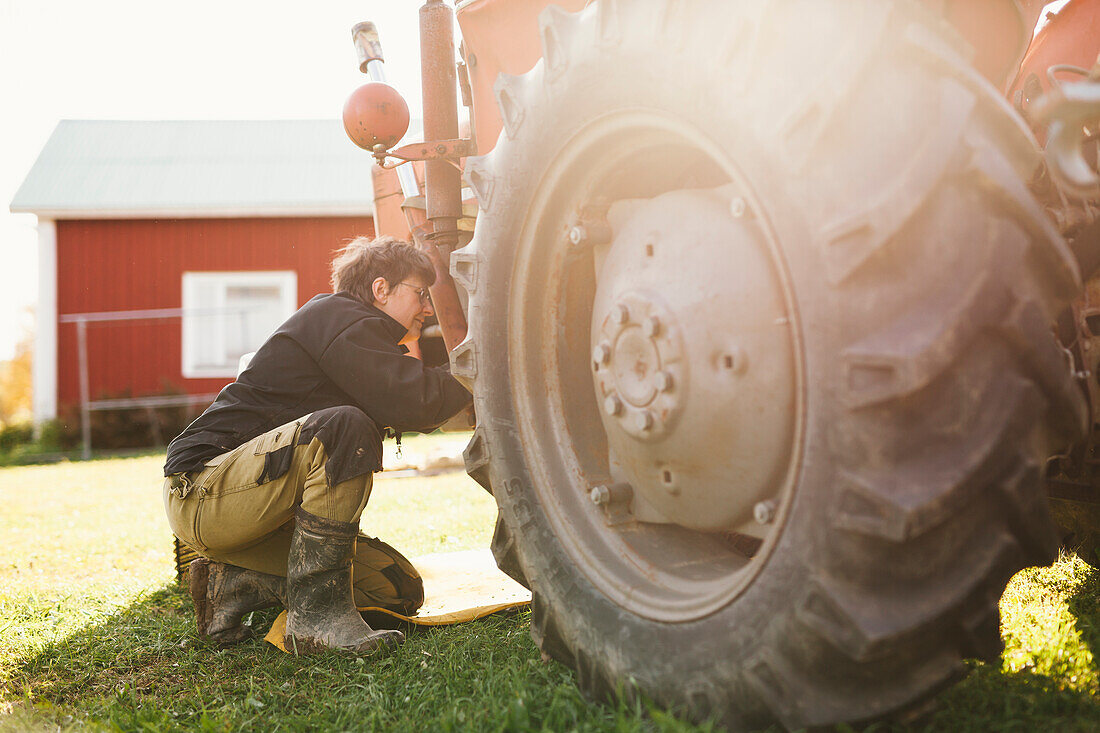 Frau repariert Traktor