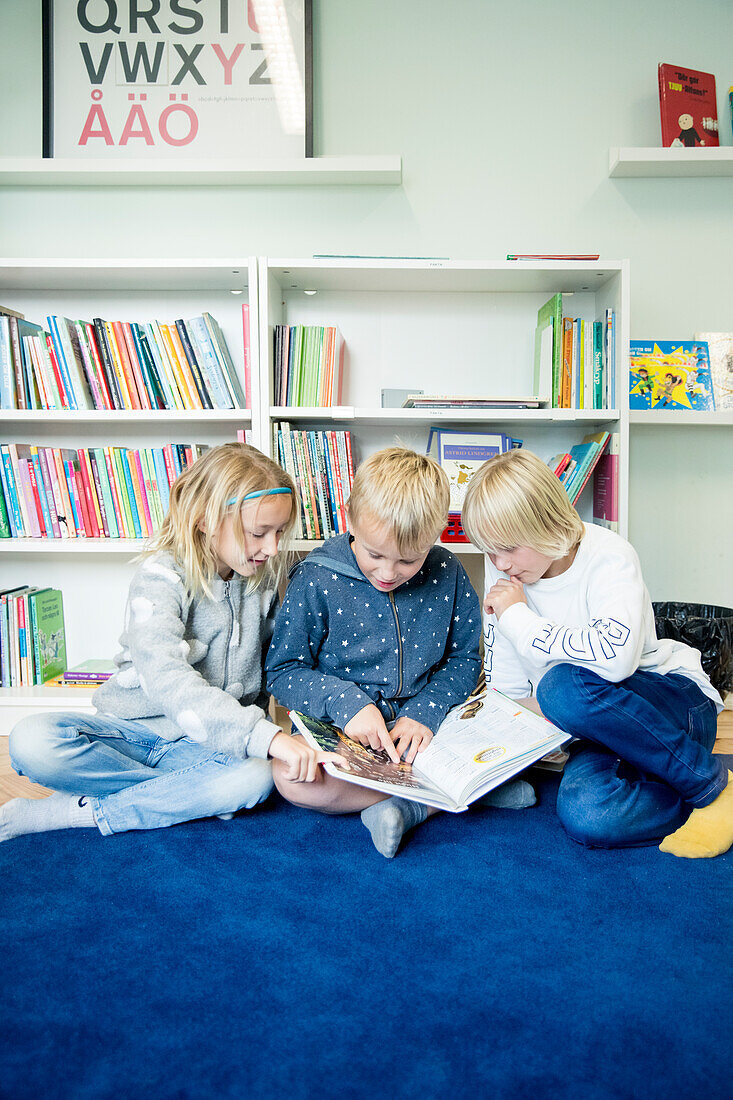 Kinder schauen gemeinsam ein Buch an