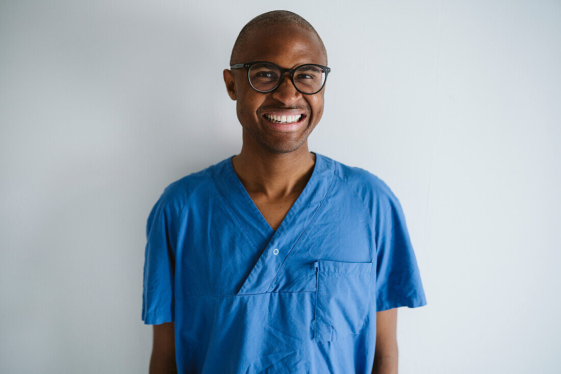 Man wearing scrubs looking at camera