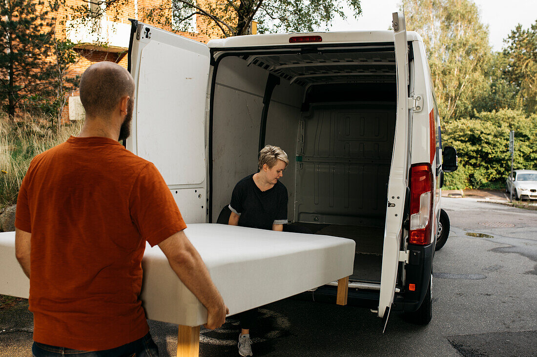 Couple putting bed into van