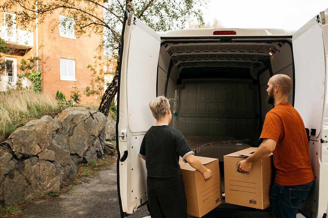 Couple putting boxes into van