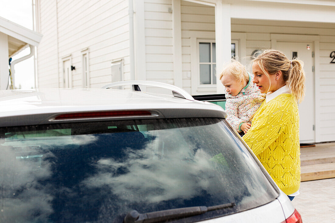 Mother with daughter near car