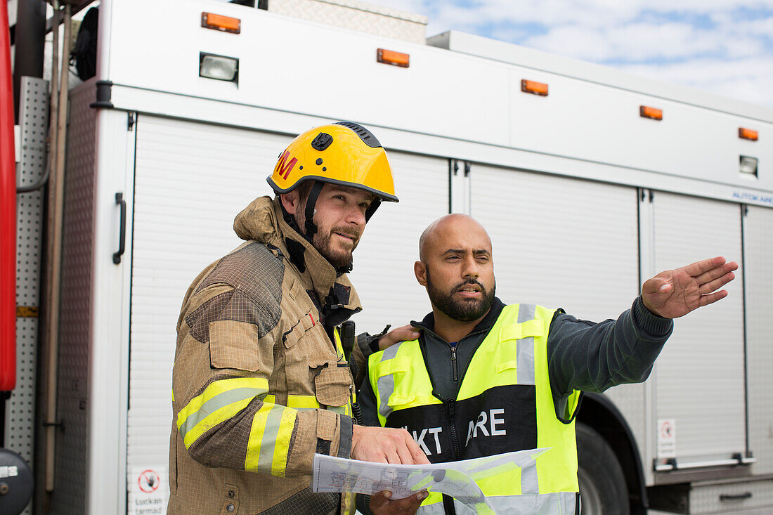 Sicherheitsbeamter und Feuerwehrleute besprechen Plan