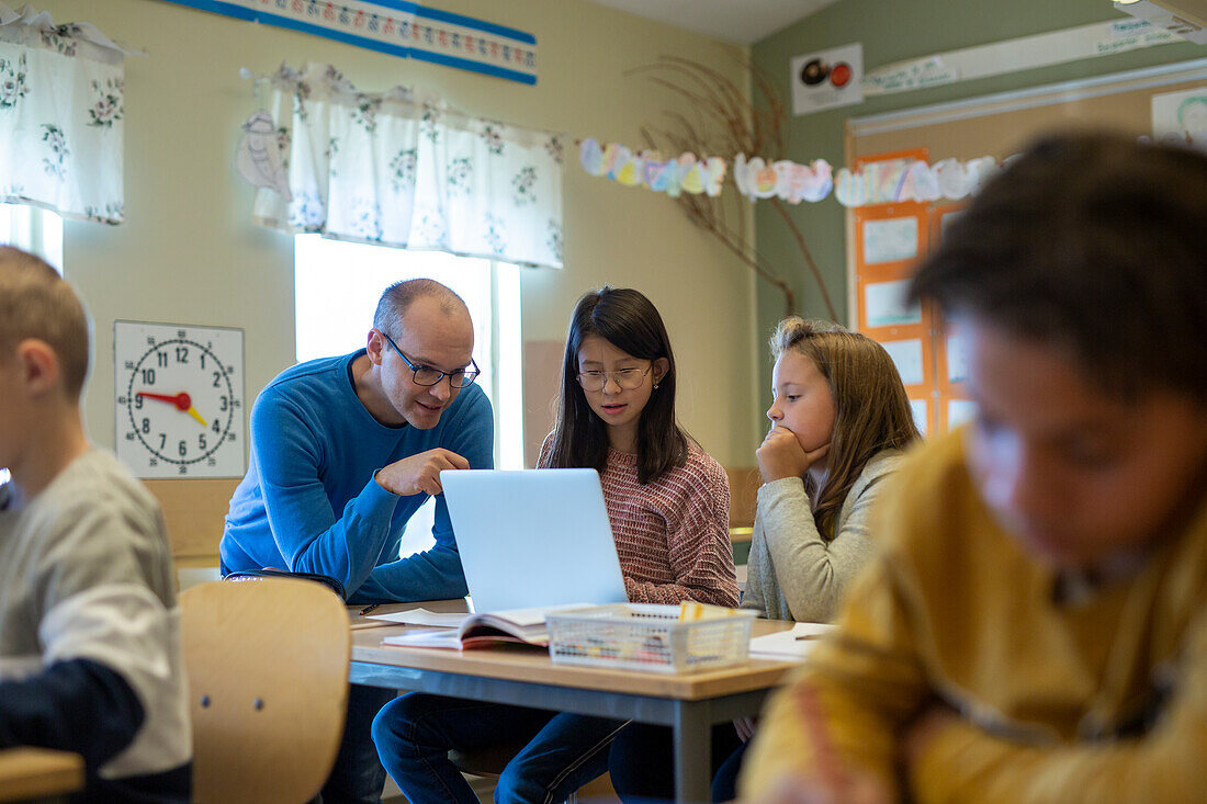 Teacher helping girls in classroom