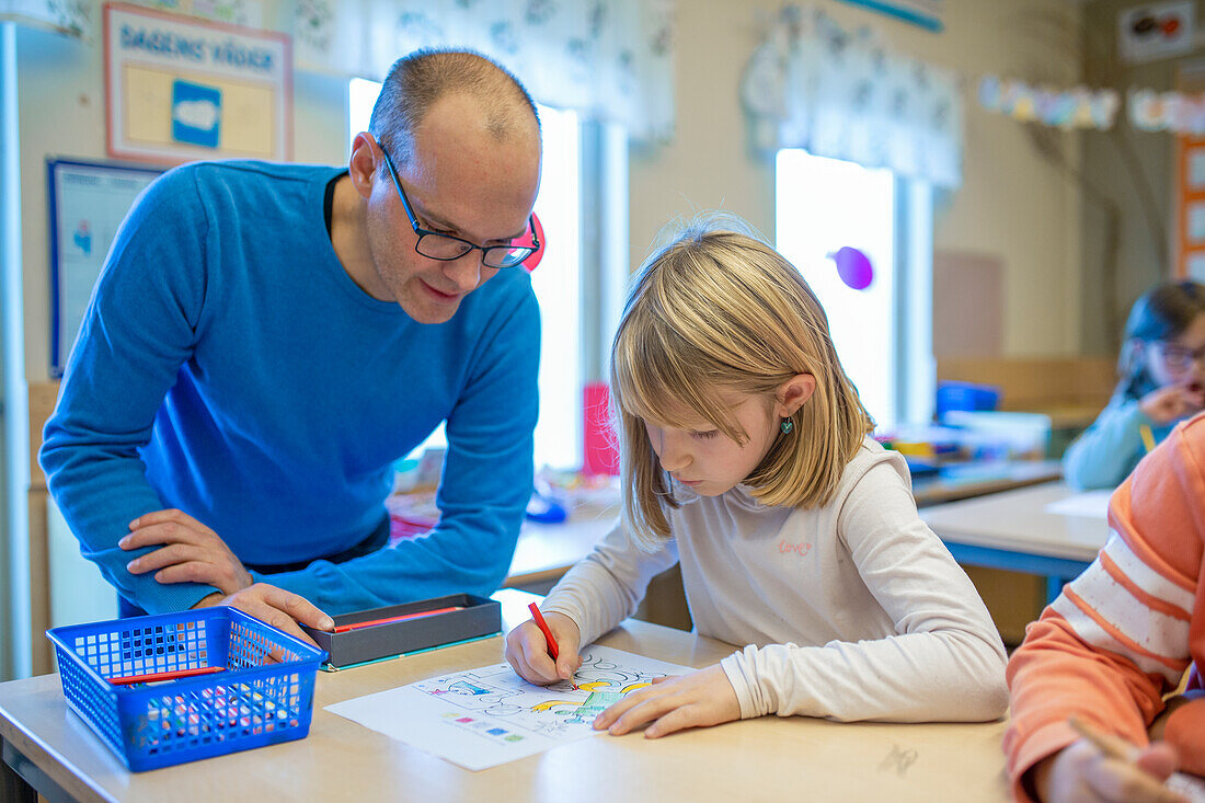 Lehrerin hilft Mädchen im Klassenzimmer
