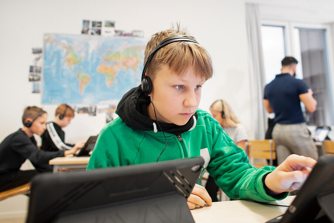 Boy in classroom using digital tablet