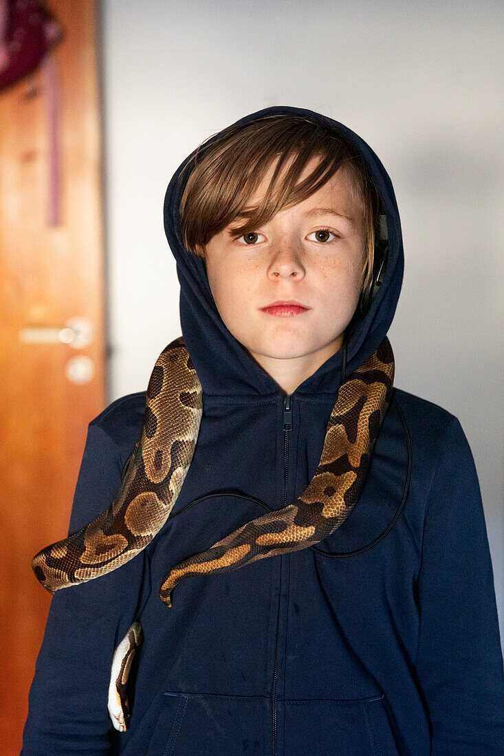 Junge mit Python auf seinen Schultern