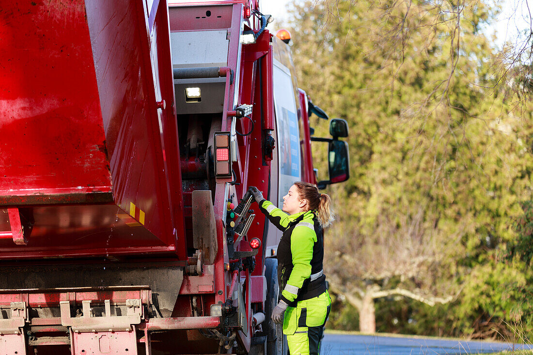 Woman operating garbage truck