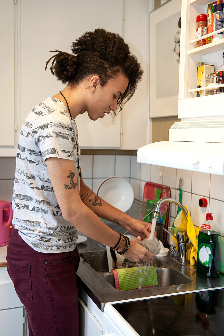 Mann wäscht Geschirr in der Küche