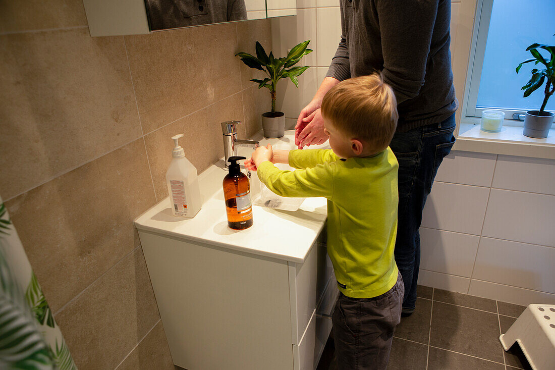 Vater und Sohn beim Händewaschen im Badezimmer