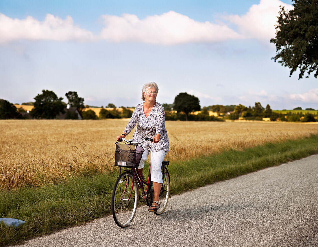 Woman cycling on rural road