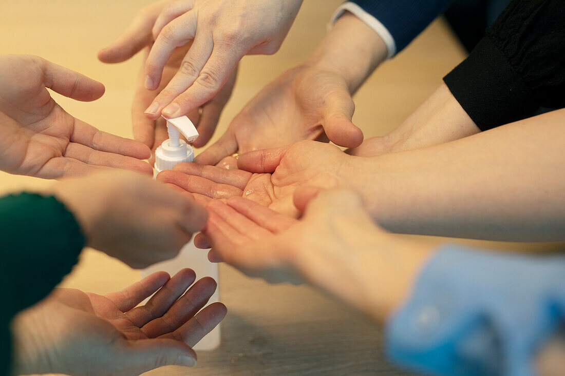 Menschen tragen Handdesinfektionsmittel auf