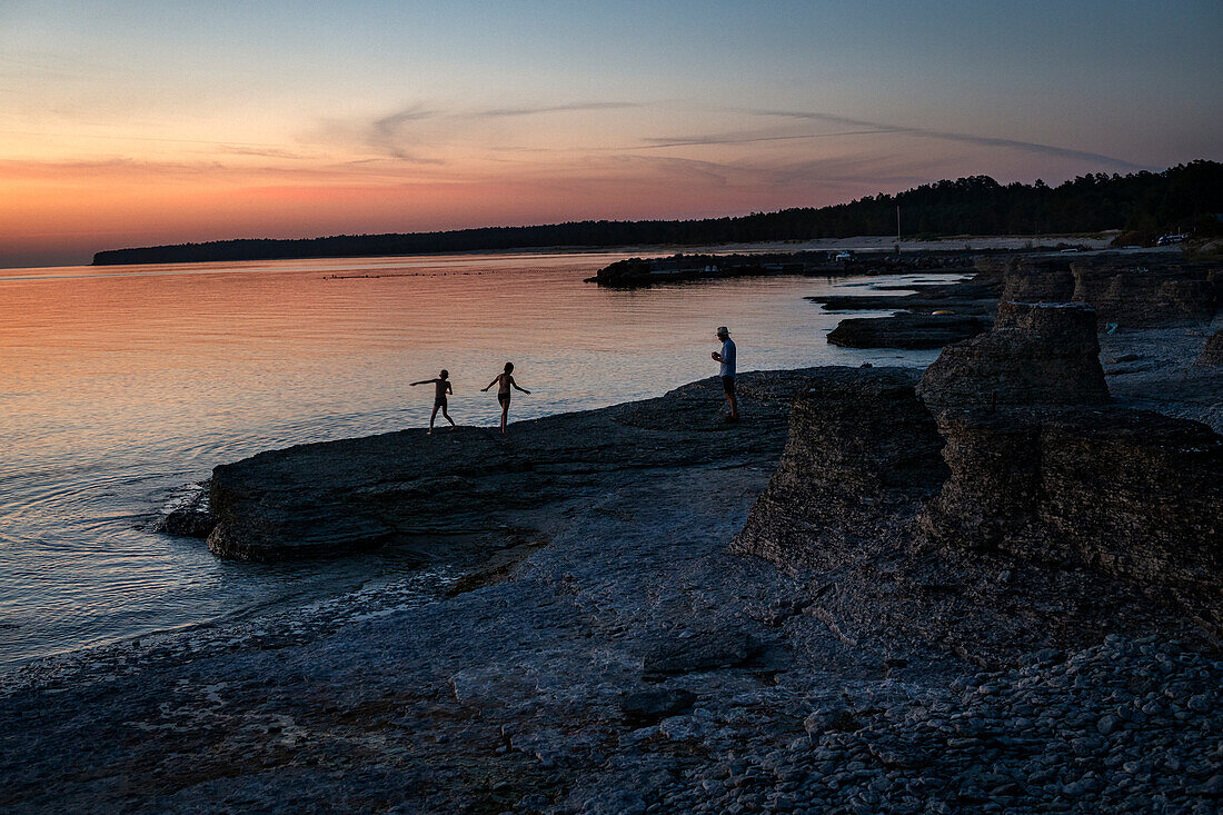 Menschen am Meer bei Sonnenuntergang