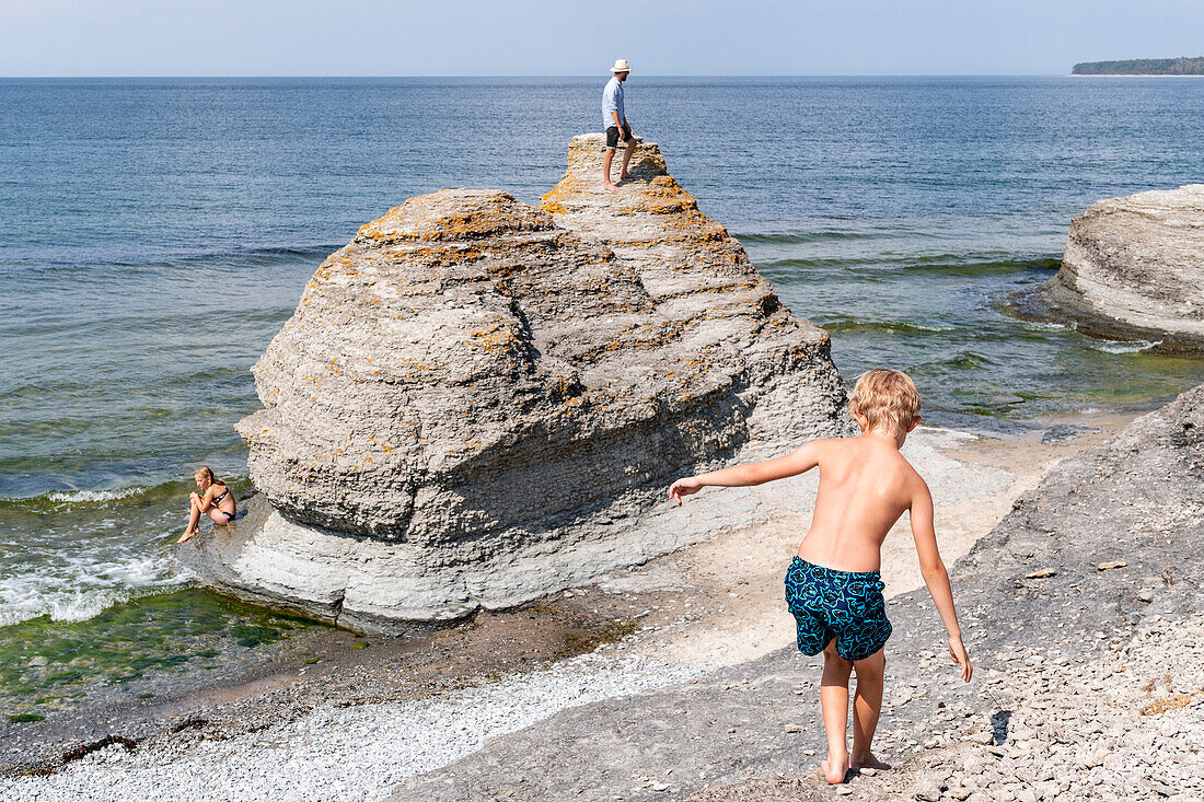 Boy walking on rocky beach