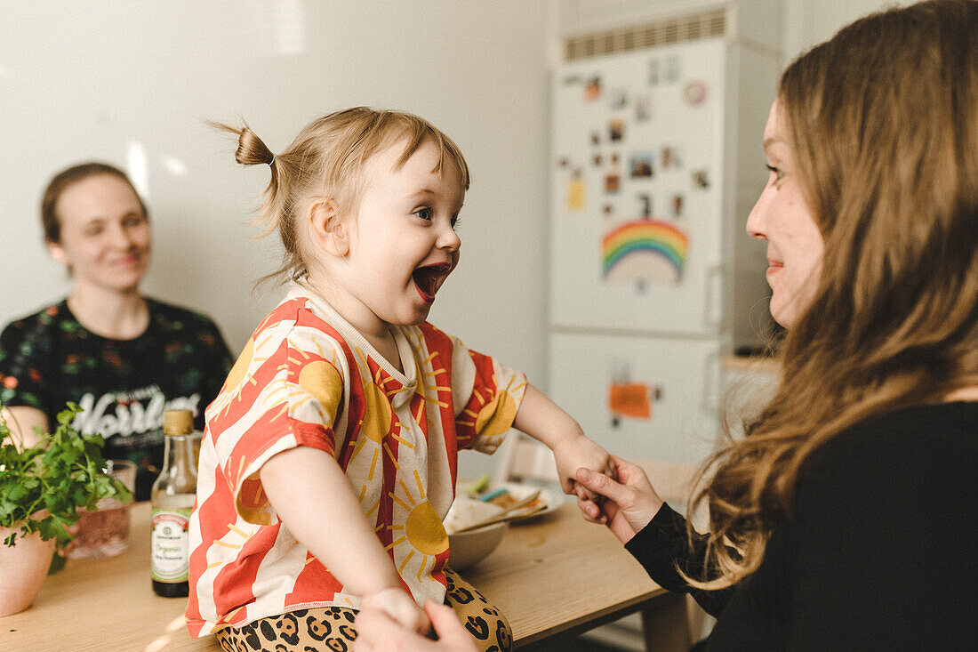 Mother with daughter sitting at table