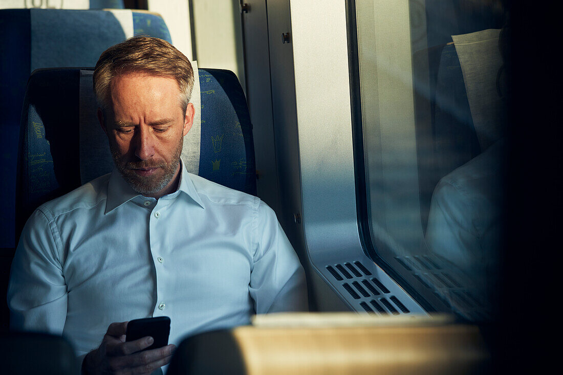 Man using cell phone in train
