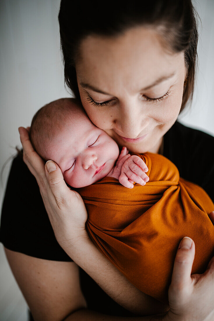Mother hugging newborn baby