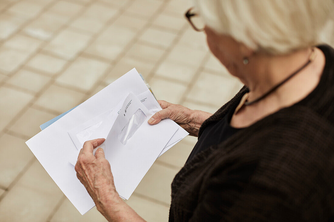 Ältere Frau hält Briefe