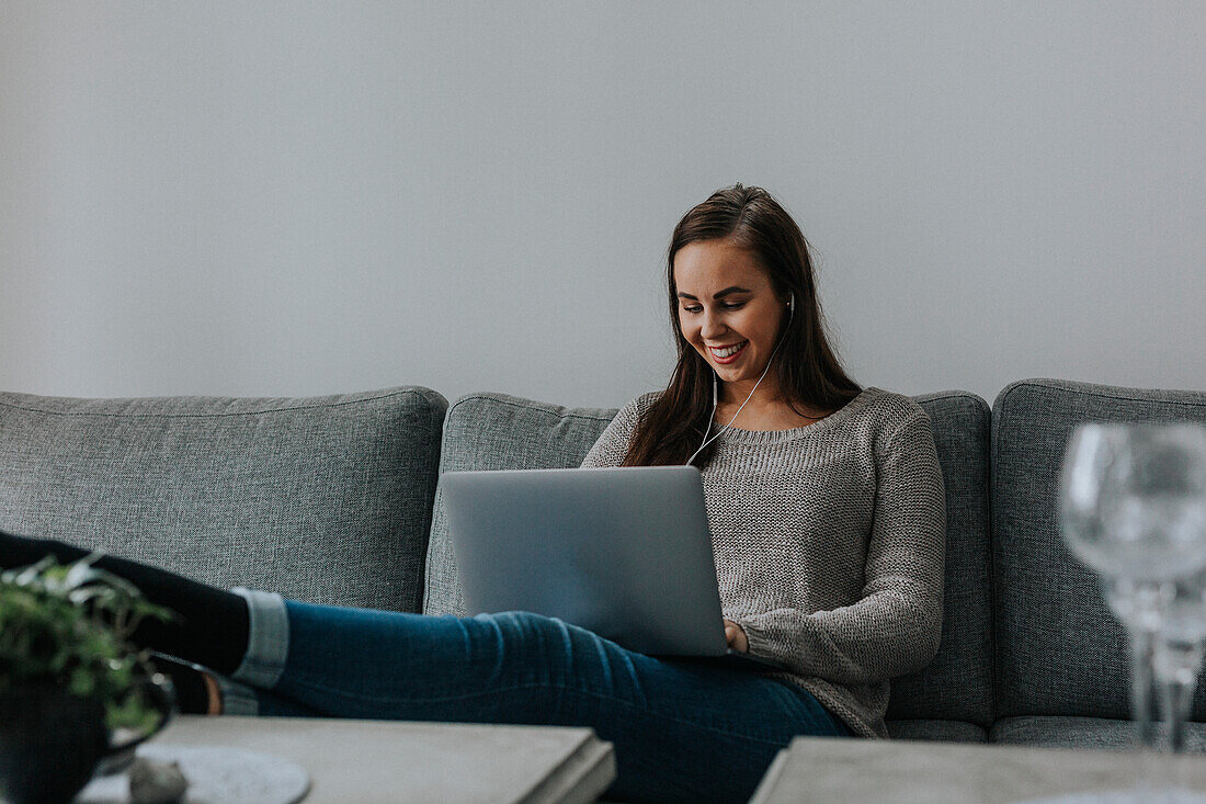 Woman on sofa using laptop