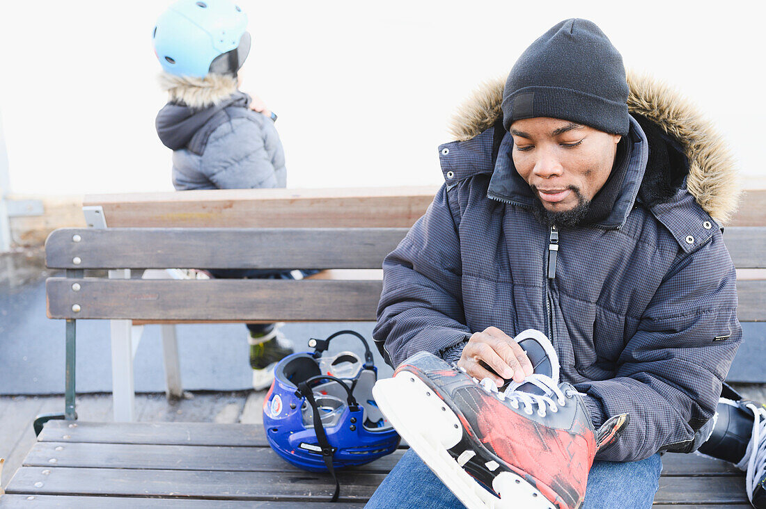 Man putting ice skates on