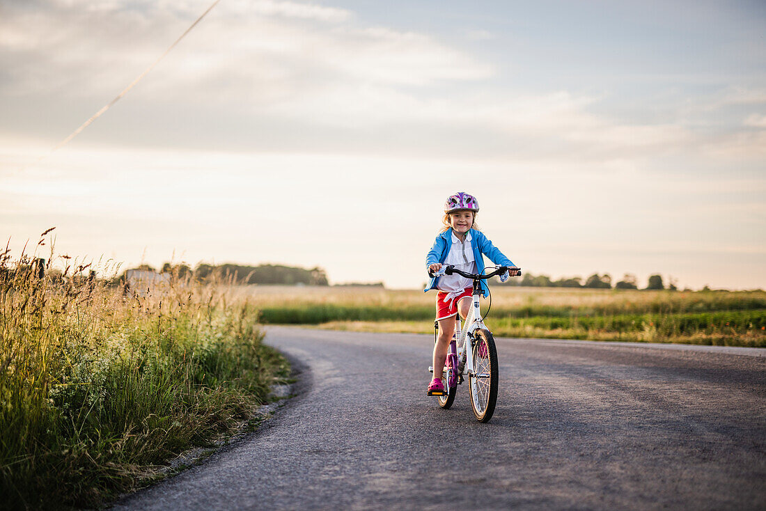 Girl cycling on country road
