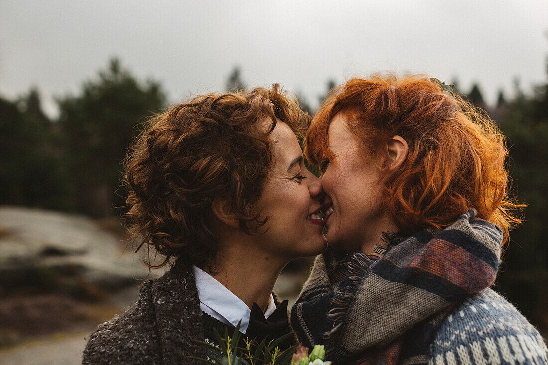 Lesbisches Paar küsst sich im Freien